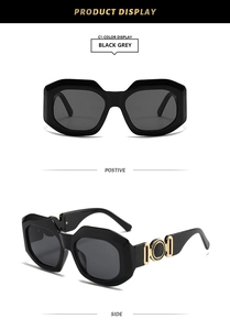 Detail view of large geometric black frame sunglasses with luxury gold metal temple accents
