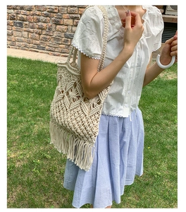 Close-up of handmade hollow-out woven tote bag featuring long fringes in bohemian style