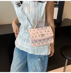 Pink quilted crossbody bag detail with star-shaped diamond buckle and silver rivets