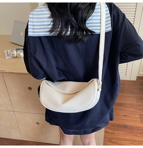 Detailed back view of white crescent tote bag with lychee texture and long strap