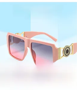 Detail of pink square sunglasses featuring a golden metal hinge with a radial logo emblem