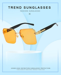 Detail view of square metal sunglasses with orange lenses and golden temple decoration
