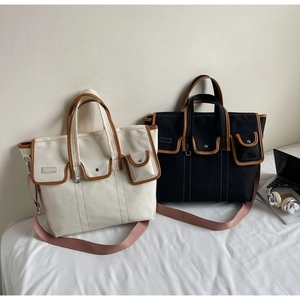 Détail du sac cabas en toile avec garniture en cuir brun et sangle en tissu violet