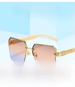 Close-up of golden square half-frame sunglasses with peach to purple gradient lenses