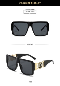 Detail view of square oversized sunglasses with black frames and gold metal hinge accents