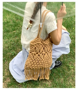 Detail of handmade macramé woven beach bag with intricate cut-outs and long fringe tassels