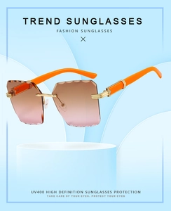Detail of rimless square sunglasses with wave-cut lenses and bright orange metal temples