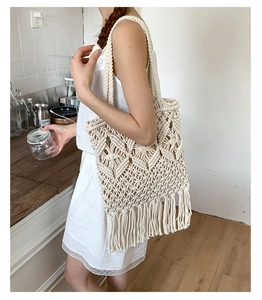 Detail of bohemian cream woven tote bag with intricate diamond patterns and long tassels