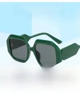 Detail of dark green geometric square frame sunglasses with thick temples on blue background