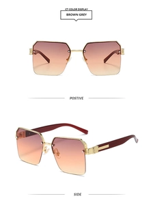 Detail view of square metal sunglasses with brown gradient lenses and golden frames