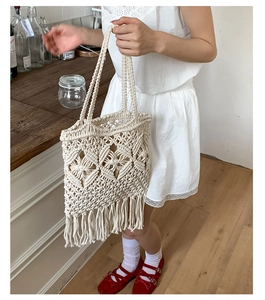 Detail of handmade cream macrame tote bag featuring bohemian fringe and woven texture