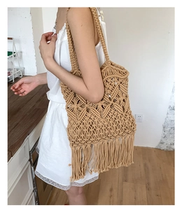 Detail of bohemian hand-woven tote bag featuring intricate crochet patterns and long tassels