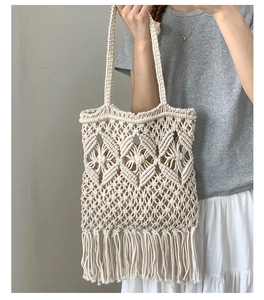 Detail of handmade cream macramé tote bag with long bohemian fringe and woven strap