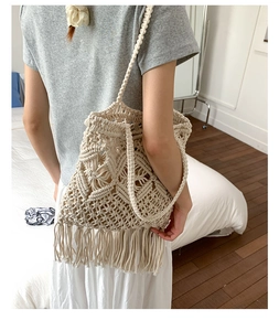 Detail of bohemian macramé woven shoulder bag featuring intricate geometric patterns and fringe