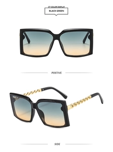 Detail view of square black sunglasses with golden chain temples and gradient lenses