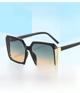 Detail of square sunglasses featuring gradient lenses and gold mesh metal temple accents