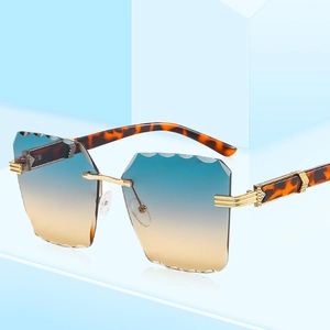 Frameless square sunglasses with gradient lenses and scallop-cut edges on blue backdrop