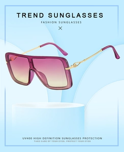 Detalle de gafas de sol cuadradas con lentes degradadas violeta-amarillo y montura dorada