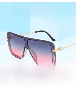 Detalle de gafas de sol cuadradas de gran tamaño con lentes degradadas y patillas oro