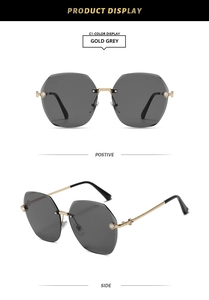 Detail of rimless gold metal sunglasses with diamond accents and grey gradient lenses