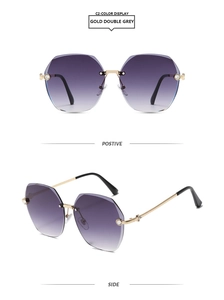 Close-up of rimless polygon sunglasses with purple gradient lenses and rhinestone accents