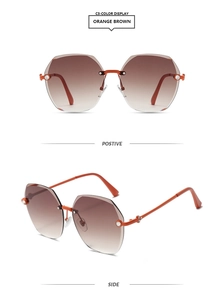 Detail of rimless heptagon sunglasses with orange brown gradient lenses and rhinestone hinge