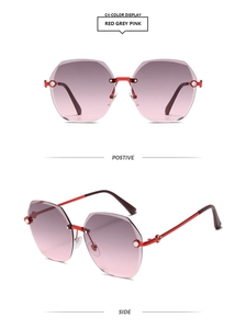 Detail view showing red metal temples and pink gradient polygon rhinestone sunglasses