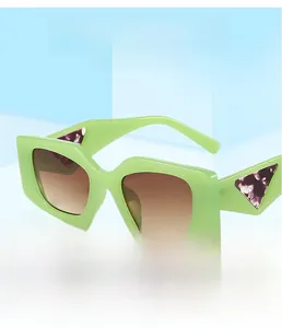 Detail of square light green sunglasses with purple floral triangle accents on temples