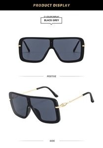 Detalle de gafas de sol cuadradas de parte superior plana con patillas metálicas doradas