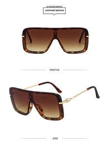 Detalle de gafas de sol cuadradas oversize de leopardo con patillas de metal dorado y lentes