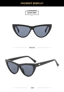 Detail view of black cat-eye sunglasses with grey lenses and silver metal side accents