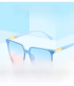 Close-up of square light blue sunglasses with gradient lenses and gold temple accents