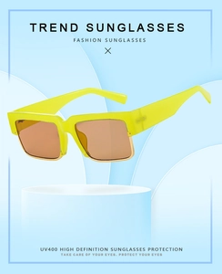 Detail of neon yellow square sunglasses with gold metal trim on a 3D display stand