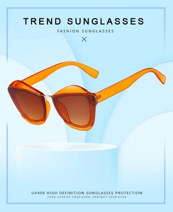 Detail of orange cat-eye sunglasses featuring UV400 lenses and durable metal hinges