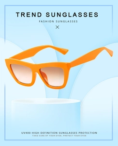 Detail of bright orange cat eye sunglasses with UV400 gradient lenses on a display stand