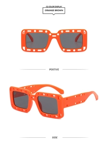 Detail of orange square sunglasses with unique cutout frame and dark gray lenses