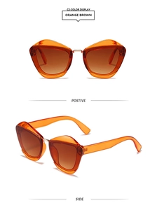 Detail view of cat eye sunglasses with orange frames and gradient brown lenses