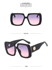 Detail of square oversized sunglasses with pink gradient lenses and wide metal-accent temples