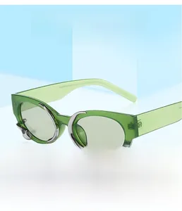 Detail of green cat eye sunglasses with silver wavy metallic accents and transparent frames