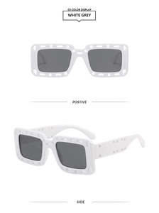 Detail of square white frame sunglasses with hollow temples and grey lenses
