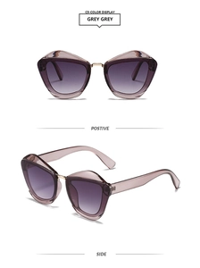 Detail of grey cat-eye sunglasses with purple gradient lenses and gold metal bridge