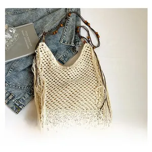 Détail du sac en macramé avec perles en bois sur les anses et longues franges