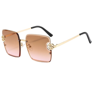 Lunettes de soleil demi-cerclées avec détails floraux dorés et verres dégradés