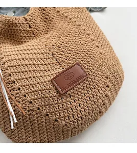 Detailed close-up of handmade crochet texture and leather dog logo on woven tote bag