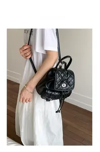 Detail of black quilted leather backpack with silver twist lock and drawstring closure