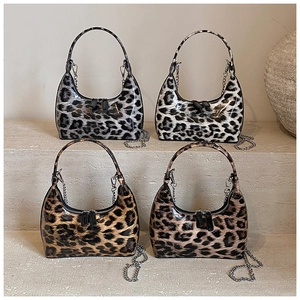 Retro leopard print hobo bag in glossy patent leather with metal chain on stone steps