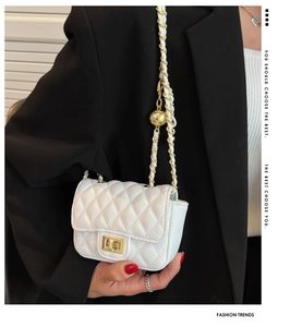 Detail of white quilted chain bag with gold metal ball adjuster and leather strap