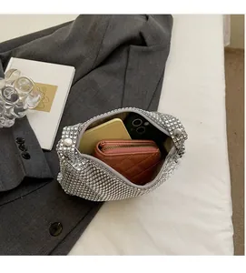 Détail de l'intérieur spacieux du sac à strass contenant un téléphone et un portefeuille
