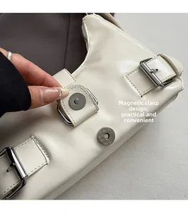Detail of white glossy leather handbag showing the convenient magnetic snap closure