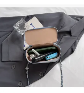 Interior view of tweed crossbody bag showing capacity for phone and cosmetics